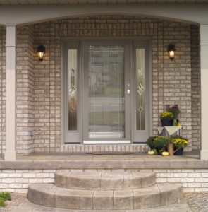 gray brick home with ProVia custom entry and storm doors installed by Paul Henry's Windows Installation